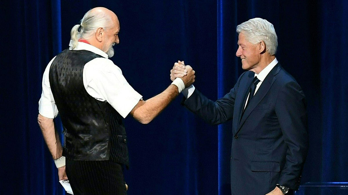 Former US president Bill Clinton (R) greets Mick Fleetwood from the band Fleetwood Mac on stage at Radio City Music Hall in New York on 26 January. Photo: AFP