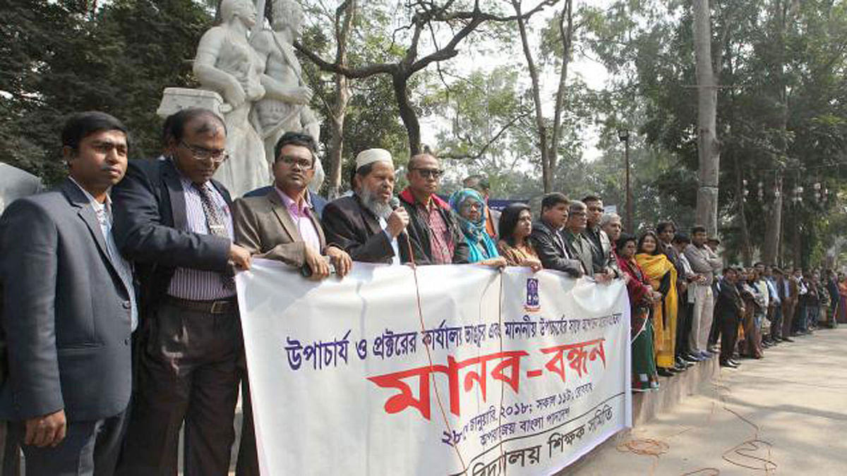 Dhaka University Teachers` Association (DUTA) forms a human chain at the feet of Aparajeyo Bangla on the campus on Sunday. Photo: Prothom Alo