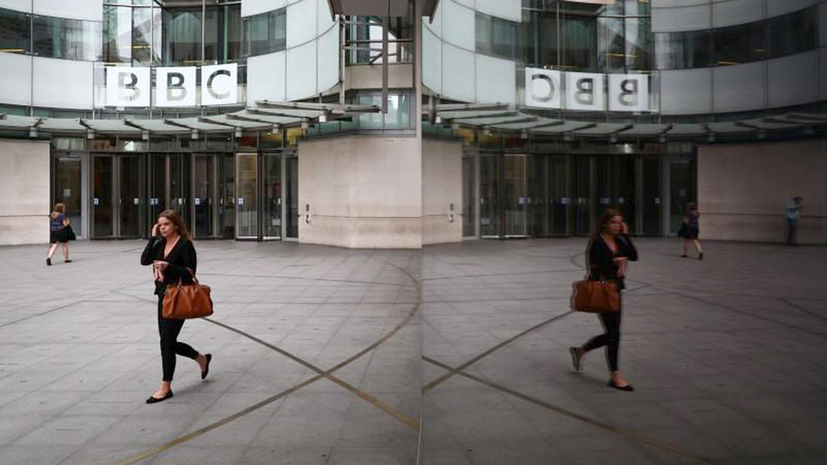 A woman is reflected as she passes the BBC’s Broadcasting House in London, Britain. Reuters file photo