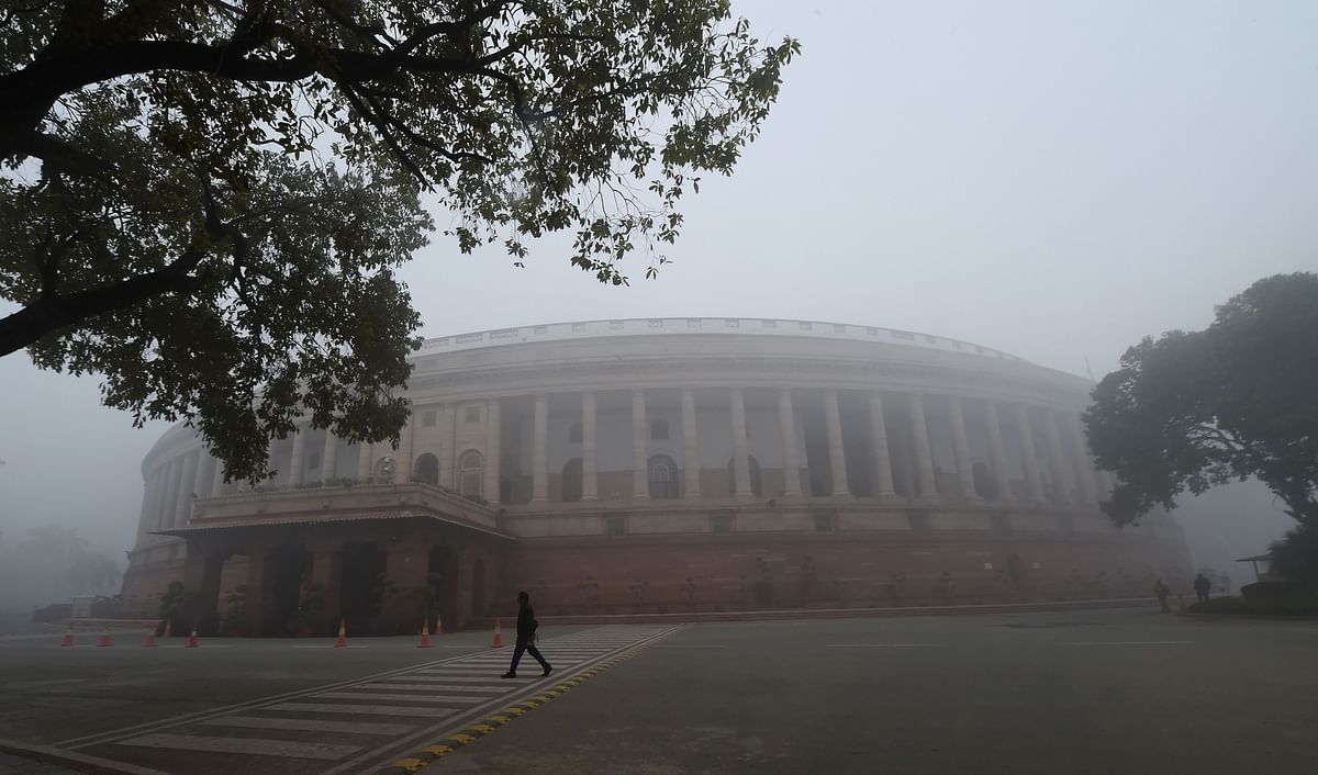 An Indian man walk past the Parliament house prior to the beginning of the budget session on a cold and foggy morning at in New Delhi on 29 January 2018. Photo: AFP