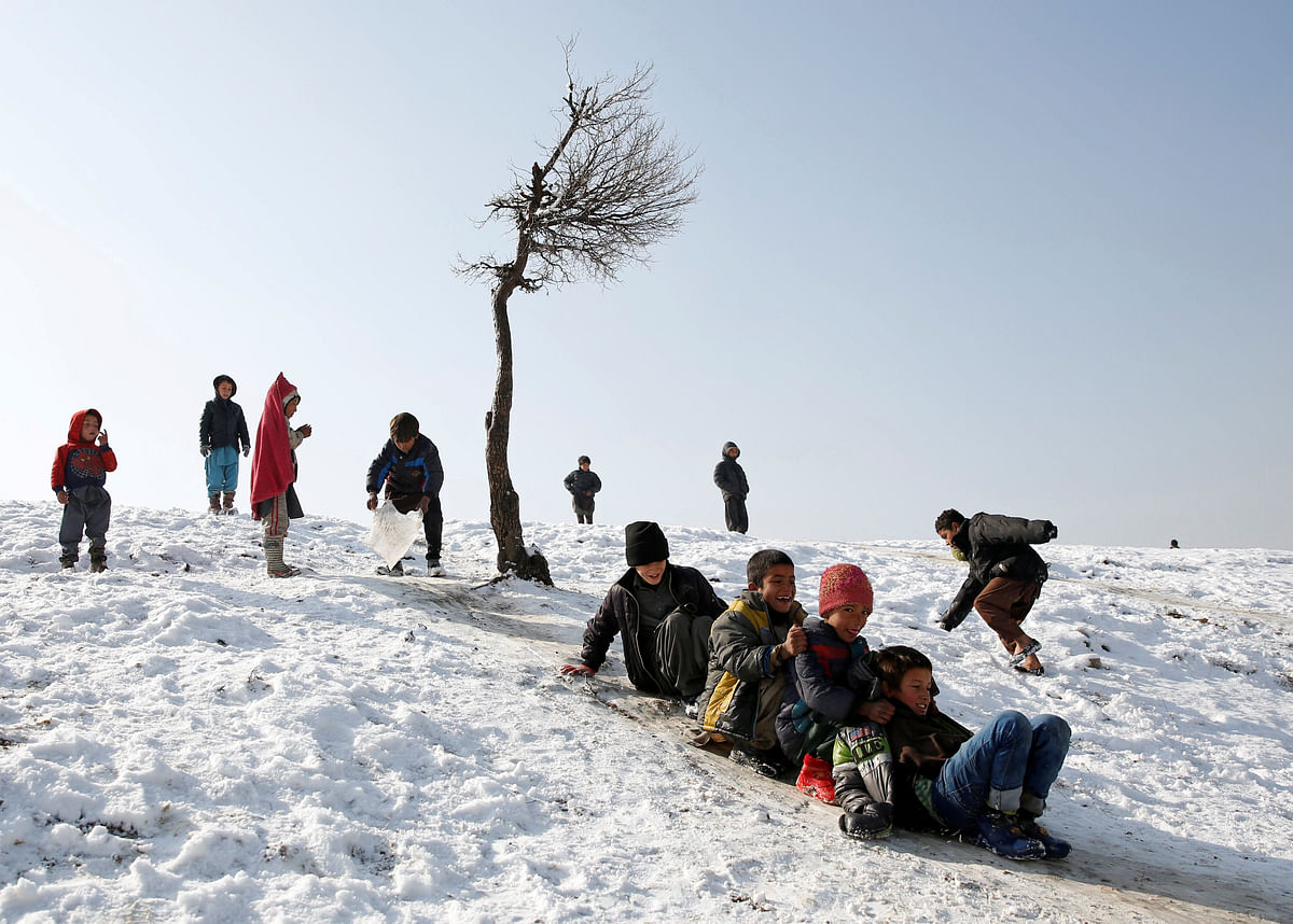 Afghan boys slide down a snow-covered slope in Kabul, Afghanistan on 30 January 2018. Photo: Reuters