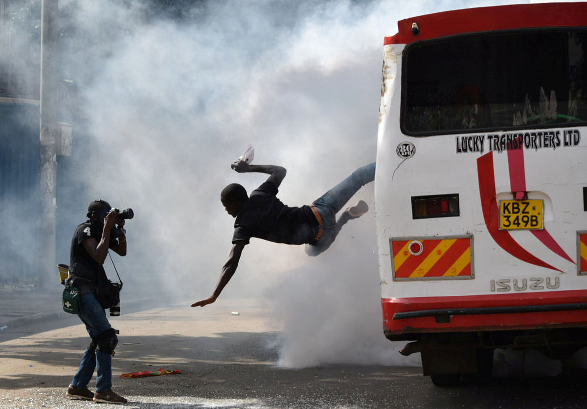 A supporter of Kenyan opposition leader Raila Odinga of the National Super Alliance (NASA) coalition jumps from a bus after riot police fired teargas canisters to disperse them after his swearing-in ceremony in Nairobi, Kenya on 30 January 2018. Photo: Reuters