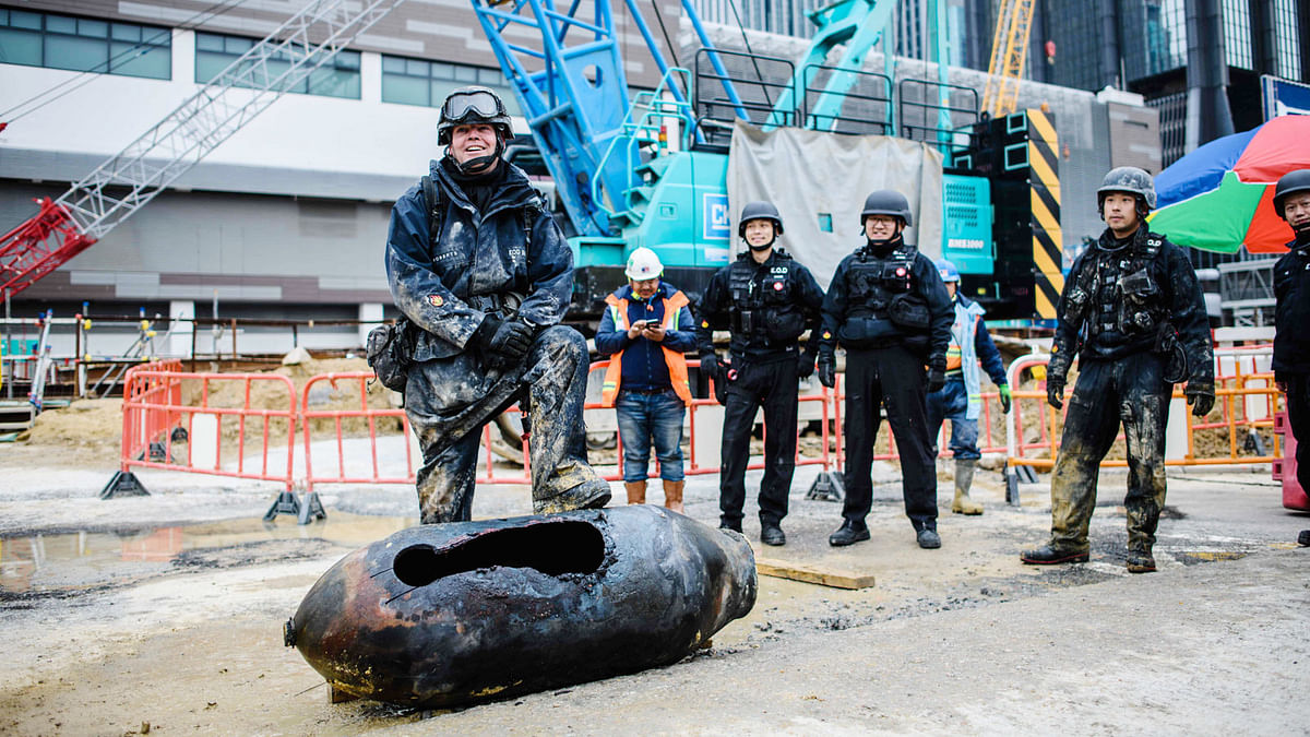 Bomb disposal expert Adam Roberts (L) rests his foot on a defused US-made bomb dropped during World War II a day after it was discovered on a harbourfront construction site in the Wan Chai district of Hong Kong on Thursday. Photo: AFP