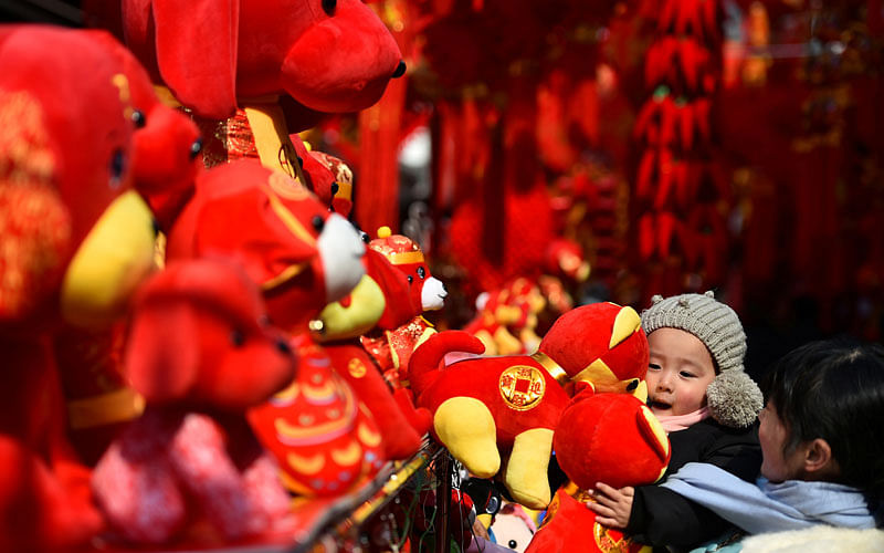 A child holds Spring Festival decorations at a market ahead of the Chinese Lunar New Year in Hefei, Anhui province, China on 3 February. Photo: Reuters