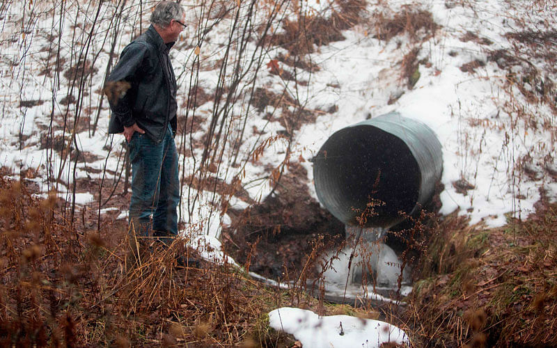 David Huff, chairperson of the zoning and planning commission for Osceola Township, stands before Chippewa Creek, shown flowing through a culvert, on 11 January 2018. Global food conglomerate Nestle is in a battle with critics in tiny Osceola Township, Michigan where residents complain the Swiss company`s water extraction techniques are ruining the environment. Photo: AFP