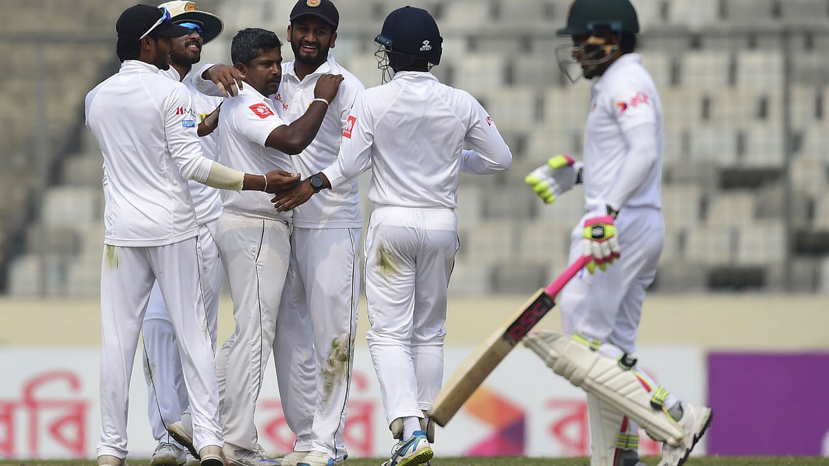 Sri Lanka cricketer Rangana Herath (2nd L) celebrates with his teammates after the dismissal of the Bangladesh cricketer Mushfiqur Rahim (R) during the third day of the second cricket Test between Bangladesh and Sri Lanka at the Sher-e-Bangla national cricket stadium in Dhaka on 10 February 2018. AFP