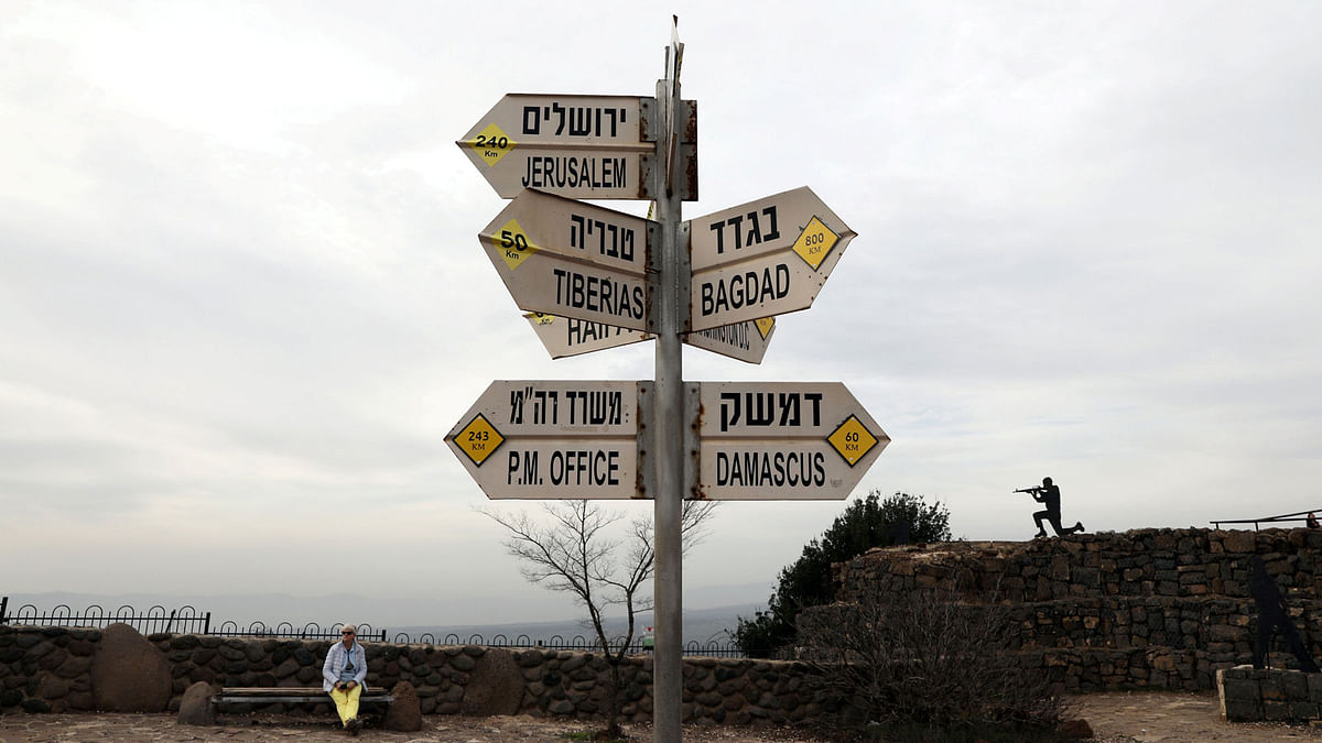 A woman sits near a sign at Mount Bental, an observation post in the Israeli-occupied Golan Heights that overlooks the Syrian side of the Quneitra crossing, Israel on 10 February 2018. Photo: Reuters