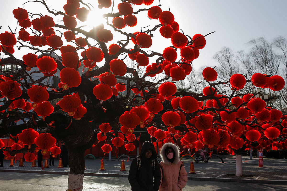 People walk under a tree decorated for Spring Festival ahead of the Chinese Lunar New Year at Ditan Park in Beijing, China 11 February 2018. Photo: Reuters