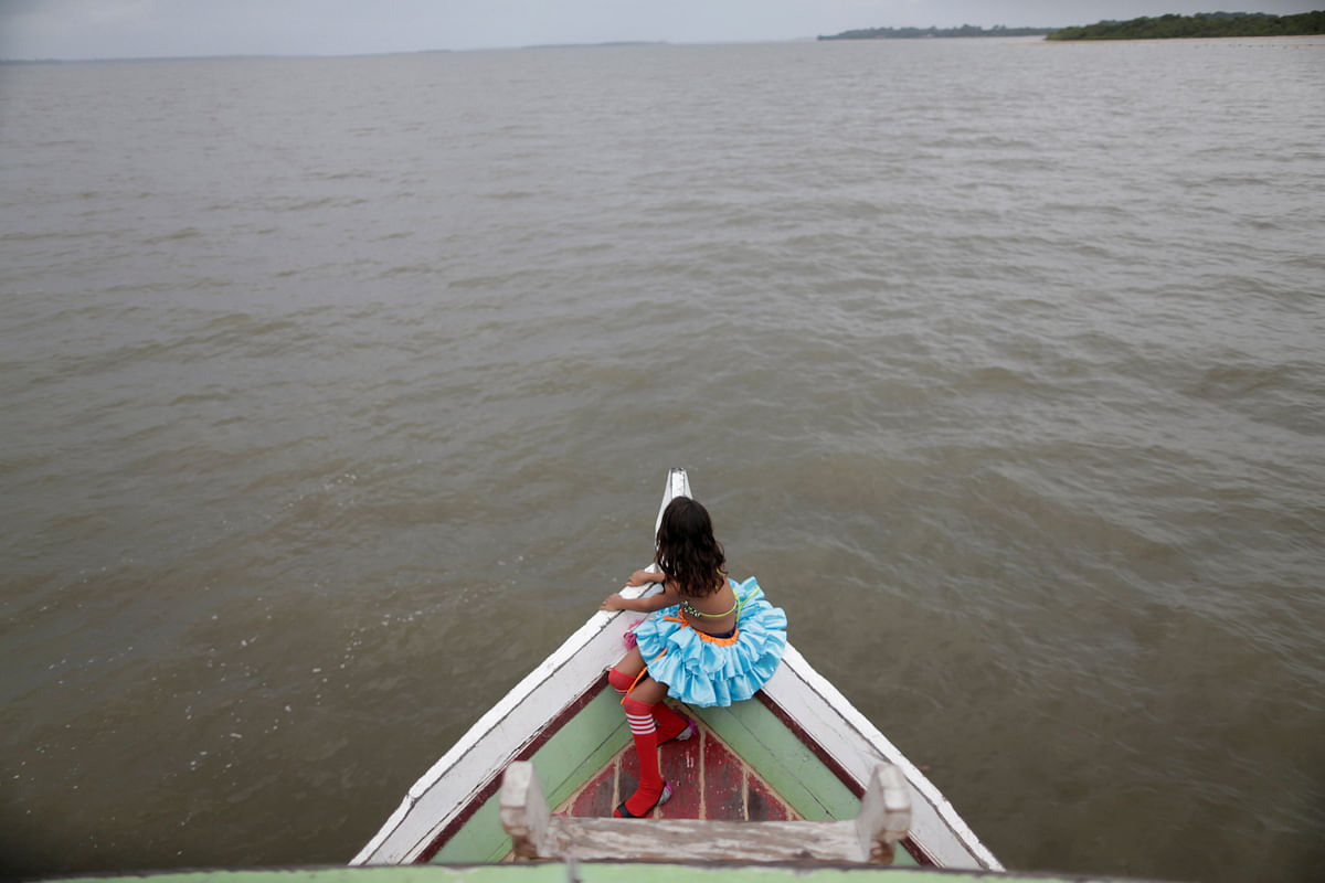 A member of the `Bloco Real Folia` group looks on during Carnival of the Waters, where costumed and colorful boats navigate the river Jaituba, around the islands near the city of Cameta, Brazil February 9, 2018. Picture taken on 9 February 2018. Photo: Reuters