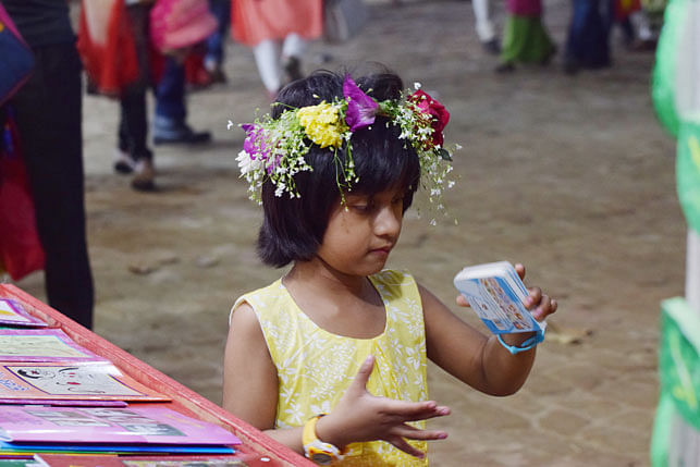 A kid lost in her thoughts at a stall at the Amar Ekushey Grantha Mela on 13 February 2018. Photo: Quamrul Hassan