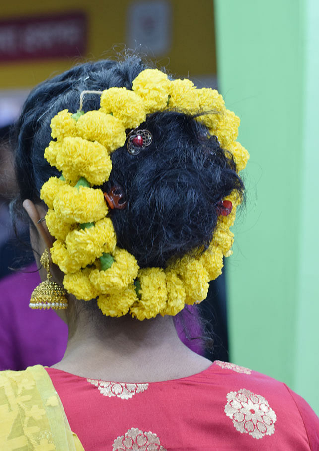 A young girl sports a garland of marigold around her hair bun. The photo was taken at the Amar Ekushey Grantha Mela on 13 February 2018. Photo: Quamrul Hassan
