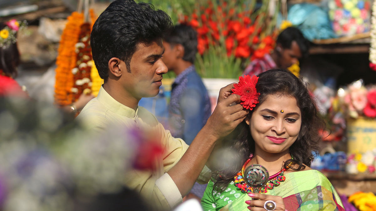 A youth adorns a lady with a flower in Shahbag, Dhaka on 13 February.  Photo: Saiful Islam