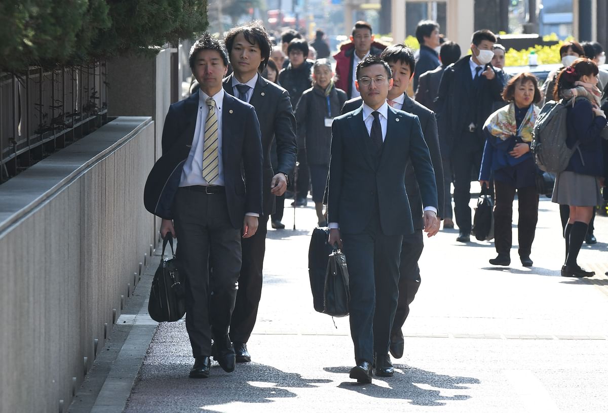 Four lawyers representing investors in Japanese exchange firm Coincheck enter the Tokyo District Court in Tokyo on Thursday. Photo: AFP