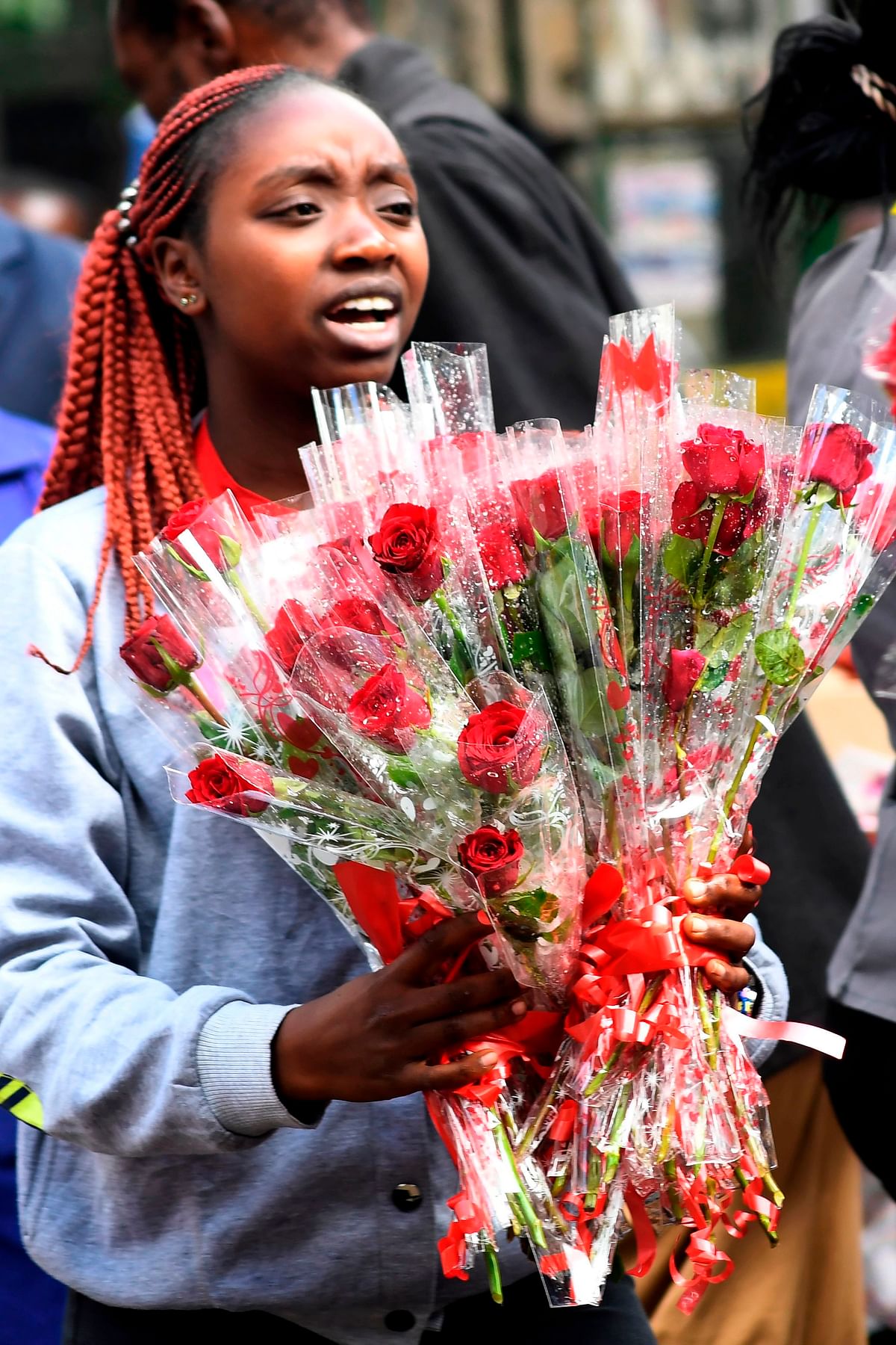 A vendor holds roses for sale for Valentine`s Day at a flower shop in Nairobi on 14 February 2018. Photo: AFP