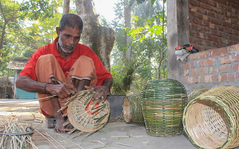 An old man weaves a bamboo basket that will be used to catch fish in Dhopakhala of Phultala upazila in Khulna on 16 February. Photo: Saddam Hossain