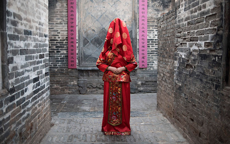 A Chinese woman dressed with a traditional bride costume, poses during a wedding performance as part of the She Huo festival, to celebrate the Lunar New Year, marking the Year of the Dog, in Hancheng, Shaanxi province, on 16 February. Photo: AFP