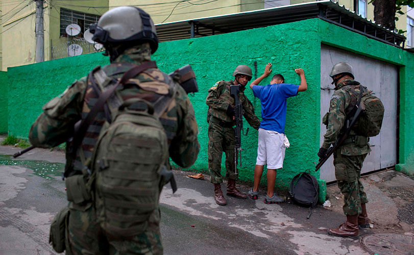 Brazilian Army soldiers frisk a resident during a joint operation at “Cidade de Deus” (City of God) favela in Rio de Janeiro, Brazil. AFP file photo