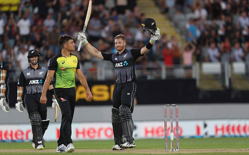 New Zealand`s Martin Guptill (R) celebrates his century as Australia`s Marcus Stoinis (2nd L) looks on, during the Twenty20 Tri Series international cricket match at Eden Park in Auckland on 18 February 2018. AFP