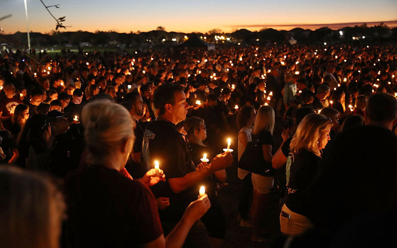 People attend a candle light memorial service for the victims of the shooting at Marjory Stoneman Douglas High School that killed 17 people on 15 February in Parkland, Florida.  Photo: AFP