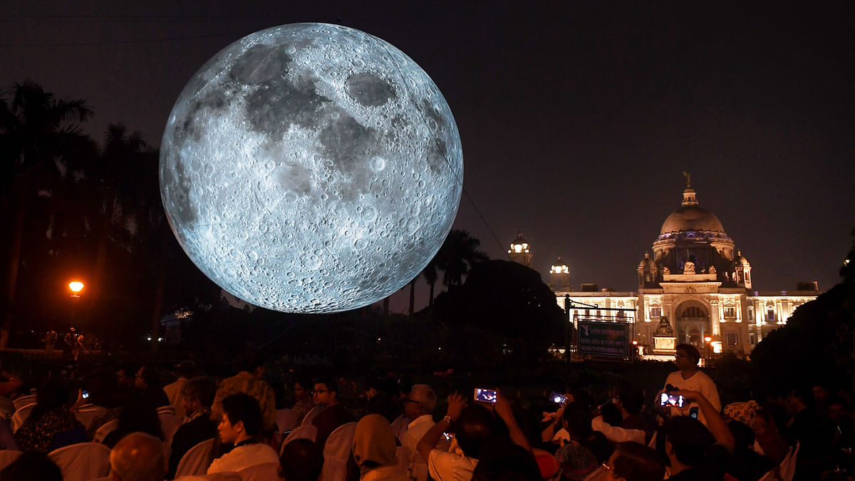 Indian visitors look at an installation depicting the moon as it is illuminated at the Victoria Memorial in Kolkata on 17 February. The `Museum of the Moon` installation was created by British artist Luke Jerram. Photo: AFP