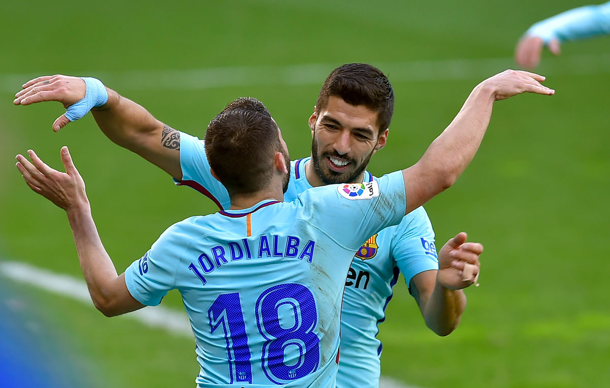 Barcelona's Spanish defender Jordi Alba (L) is congratulated by teammate Uruguayan forward Luis Suarez for scoring the team's second goal during the Spanish league football match between SD Eibar and FC Barcelona at the Ipurua stadium in Eibar on 17 February, 2018. Photo: AFP