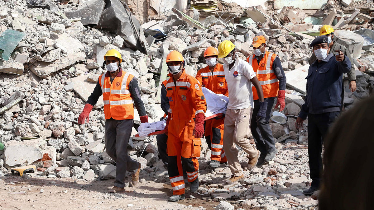 NDRF and SDRF workers carry a dead body after a building collapsed due to a gas cylinder blast during wedding party in Beawar, in the Indian state of Rajasthan on 18 February, 2018. Phone: AFP