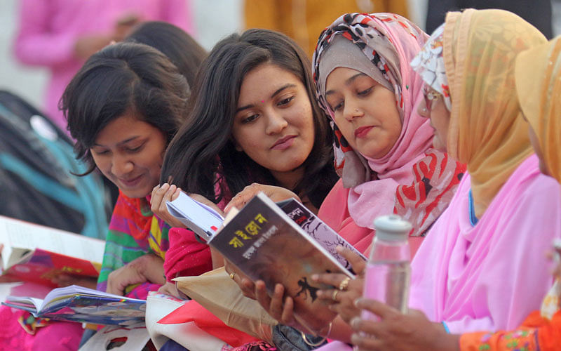 Several women are reading books at the Ekushey Book Fair at Suhrawardy Udyan in the capital on 19 February 2018. Photo: Saiful Islam