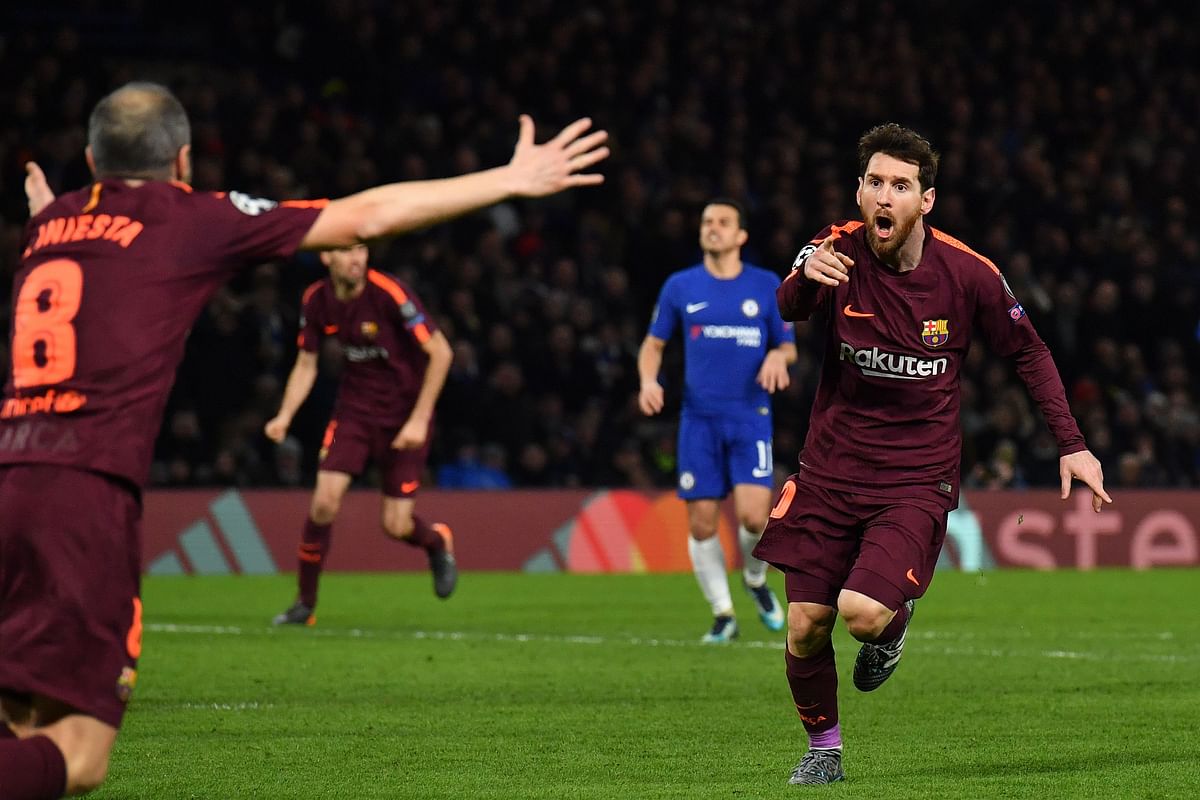 Barcelona’s Argentinian striker Lionel Messi ® celebrates with Barcelona’s Spanish midfielder Andres Iniesta (L) after scoring their first goal during the first leg of the UEFA Champions League round of 16 football match between Chelsea and Barcelona at Stamford Bridge stadium in London on Tuesday. Photo: AFP