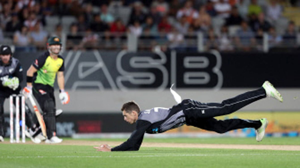New Zealand`s Mitchell Santner (R) fields a ball off his own bowling during the final Twenty20 Tri Series international cricket match between New Zealand and Australia at Eden Park in Auckland on 21 February 2018. Photo: AFP