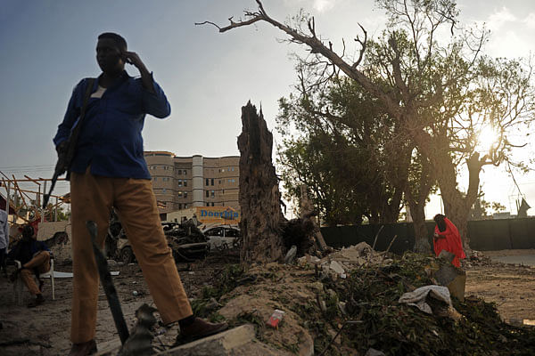 Somali security officer stands guard at the scene of a suicide car explosion in front of Doorbin hotel in Mogadishu, on Saturday. Photo: AFP