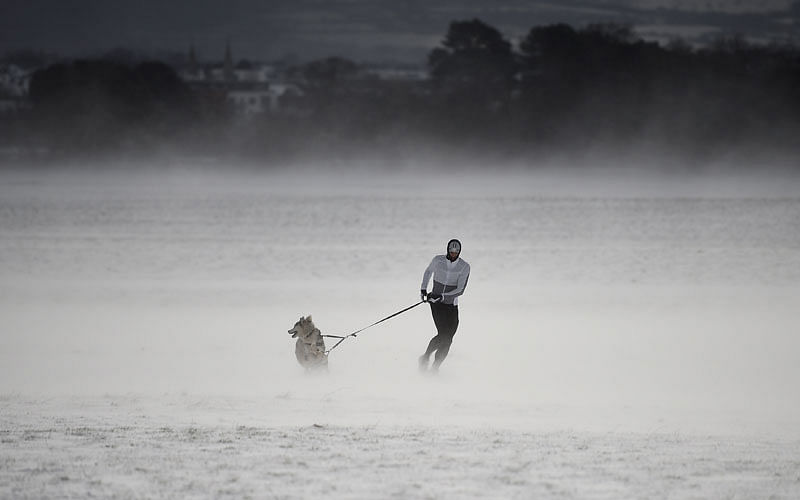 A man runs through the snow with his husky dog at the Phoenix Park in Dublin, Ireland, 28 February. Photo: Reuters