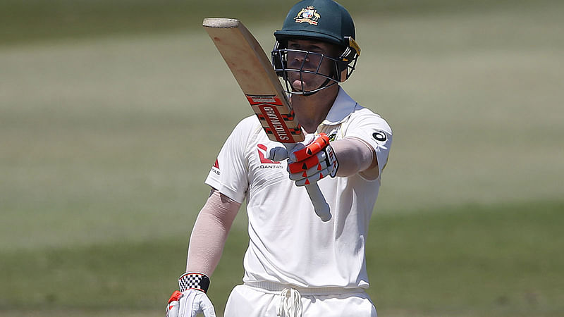 David Warner raises his bat as he celebrates his fifty. AFP