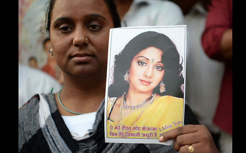 A woman holds a picture of late Bollywood actress Sridevi Kapoor as she stands outside her house before Sridevi`s funeral in Mumbai on 28 February 2018. Photo: AFP