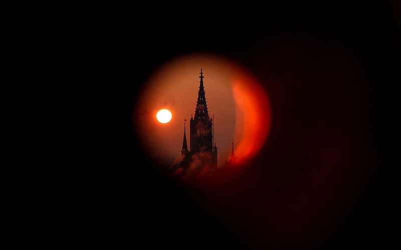 The sun rises behind the Muenster Cathedral during a cold morning in Bern, Switzerland on 28 February. Picture taken through a metal pipe. Photo: Reuters