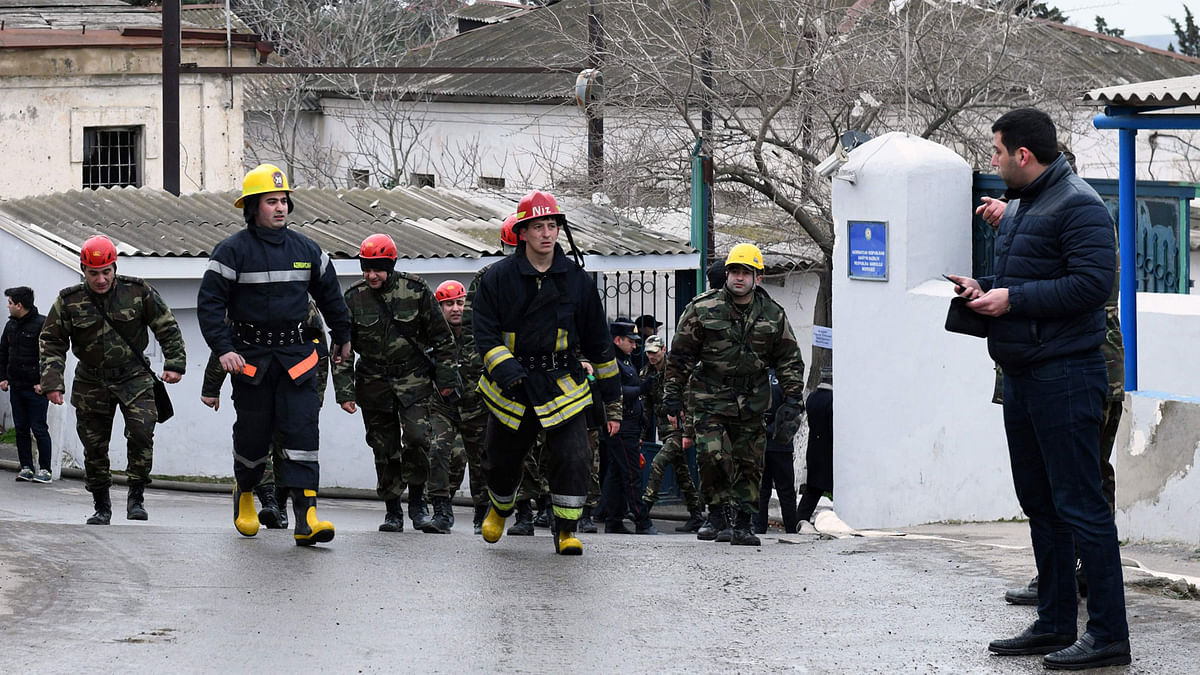Firefighters walk near the site of a fire in a drug rehabilitation clinic in Baku on 2 March, 2018. Photo: AFP