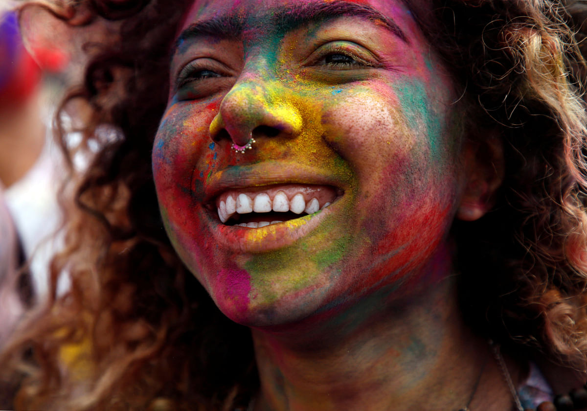 A woman, smeared with coloured powder, dance while celebrating Holi, the festival of colours, in Kathmandu, Nepal on 1 March. Photo: Reuters
