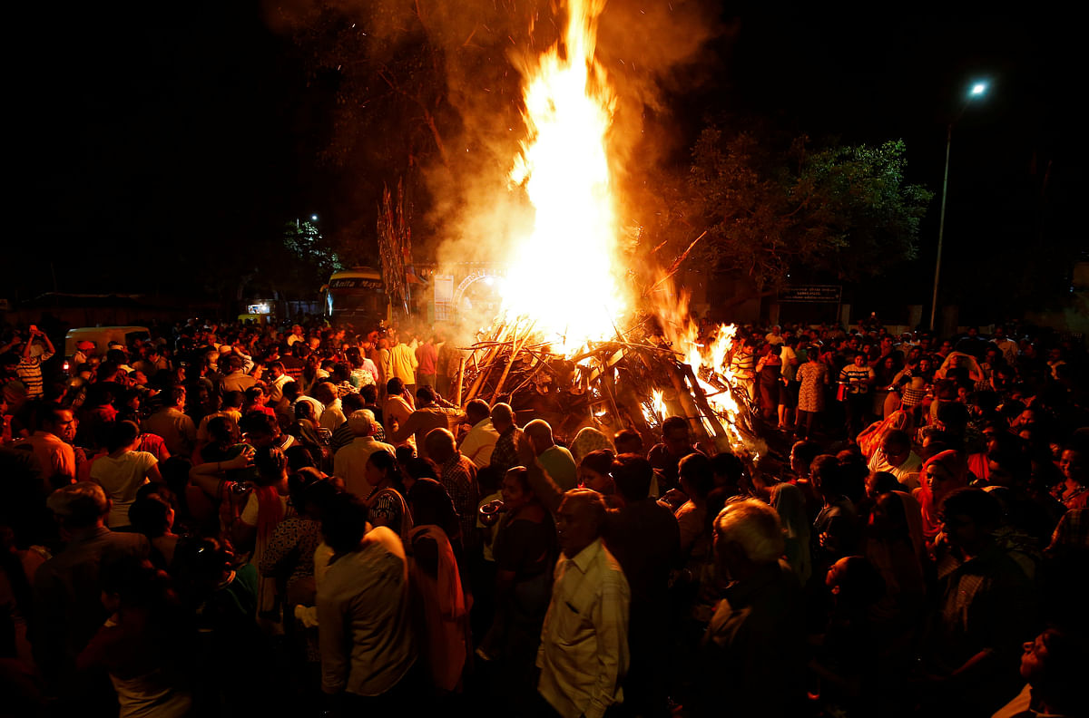Hindu devotees walk around a bonfire during a ritual known as `Holika Dahan` which is part of Holi festival celebrations, in Ahmedabad, India on 1 March 2018. Photo: Reuters