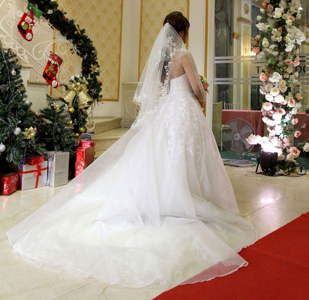 In this picture taken on January 23, 2018, Vietnamese bride Huong enters the wedding hall for the ceremony in Hanoi. Young couples are shelling out thousands of dollars to rent parents, aunts, uncles, godparents and friends to appease familial pressure to get married or avoid clashes between in-laws who disapprove of the union.