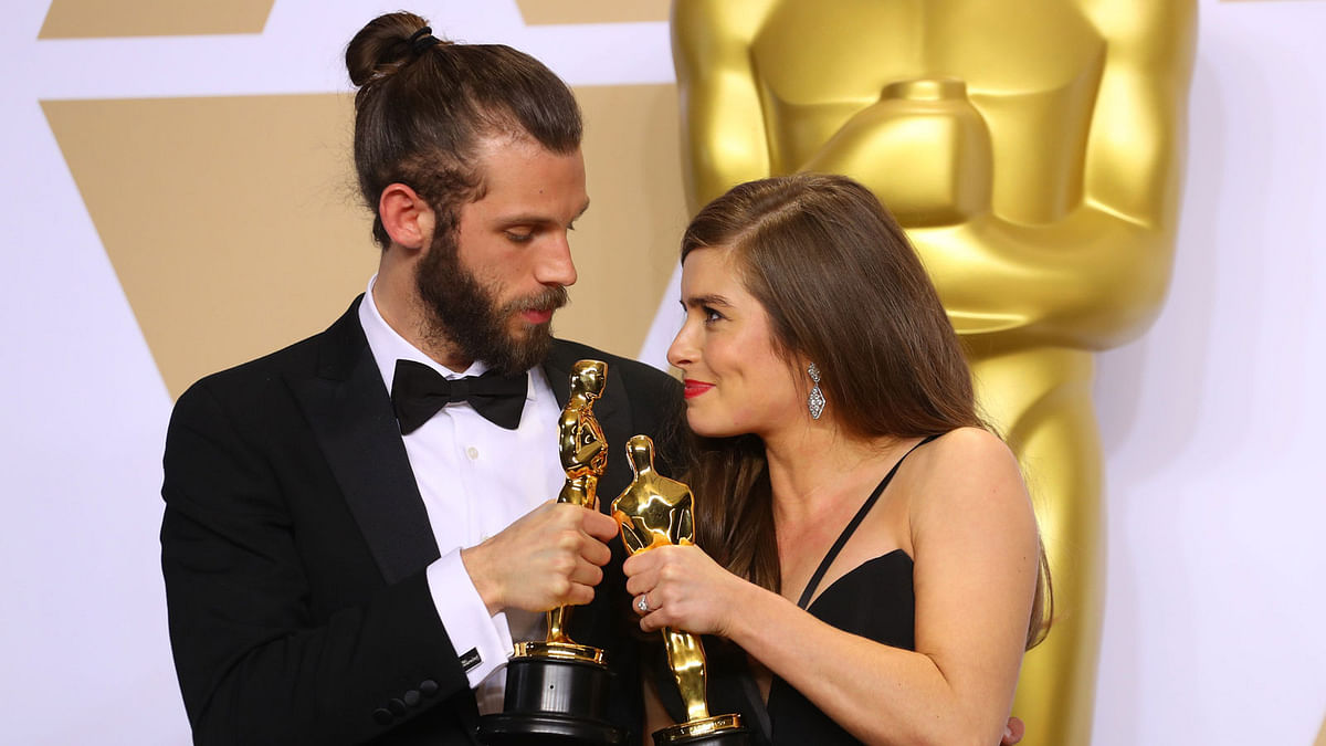 Chris Overton and Rachel Shenton hold their Oscars for Live Action Short `The Silent Child`. Photo: Reuters