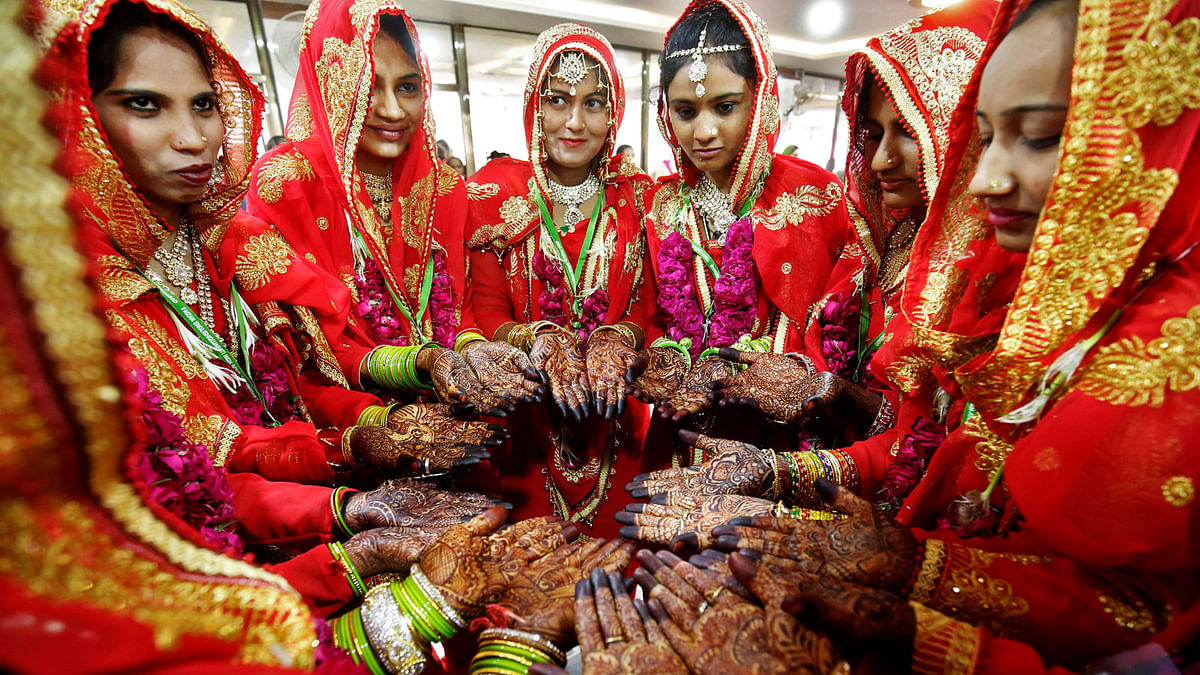 Brides pose as they display their hands decorated with henna before taking their wedding vows during a mass marriage ceremony in Ahmedabad, India on 4 March. Photo: Reuters