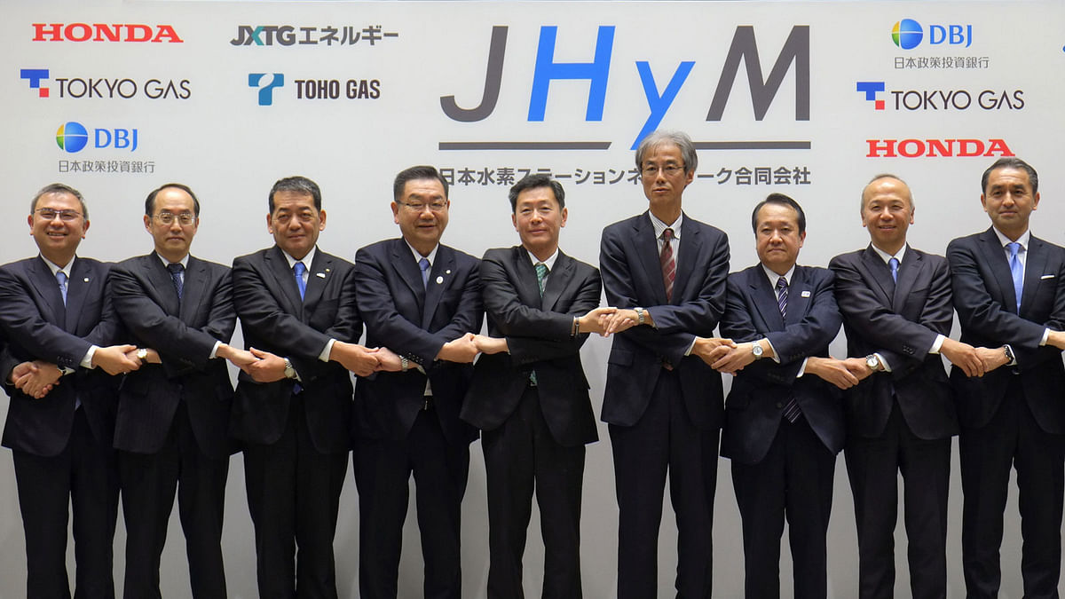Japan H2 Mobility President Hideki Sugawara (5th L) and representatives of its joint establishment companies hold hands during a photo session after their joint press conference in Tokyo on 5 March, 2018. Photo: AFP