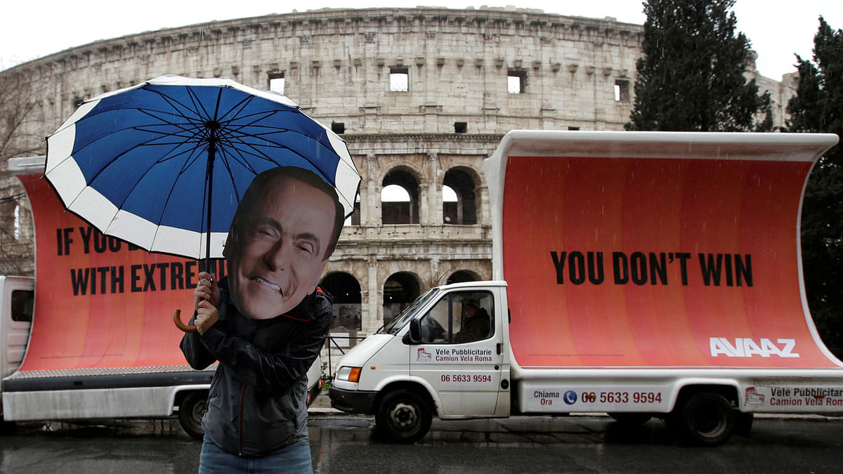 An activist wearing a mask of Forza Italia party leader Silvio Berlusconi poses during a tour, the day after Italy`s parliamentary elections, in Rome, Italy on 5 March. Photo: Reuters.