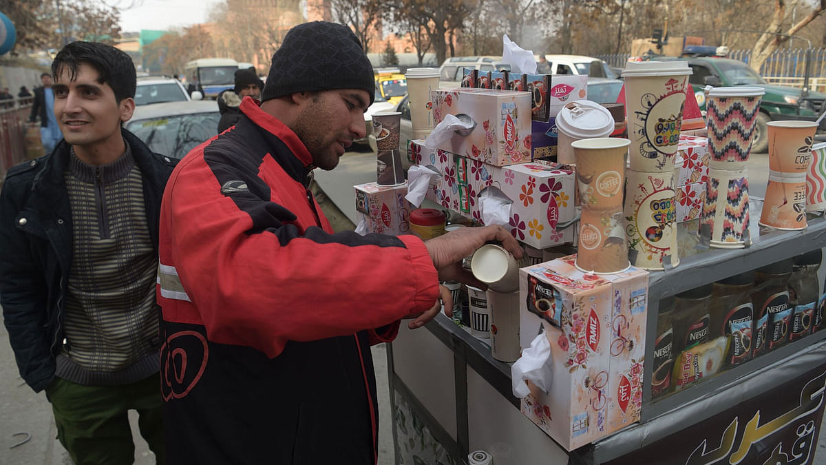 Najibullah Sharyari ©, 30, prepares coffee for customers at his cart in Kabul. Afghans in need of a caffeine fix line up at Najibullah Sharyari’s coffee cart in Kabul. Photo: AFP