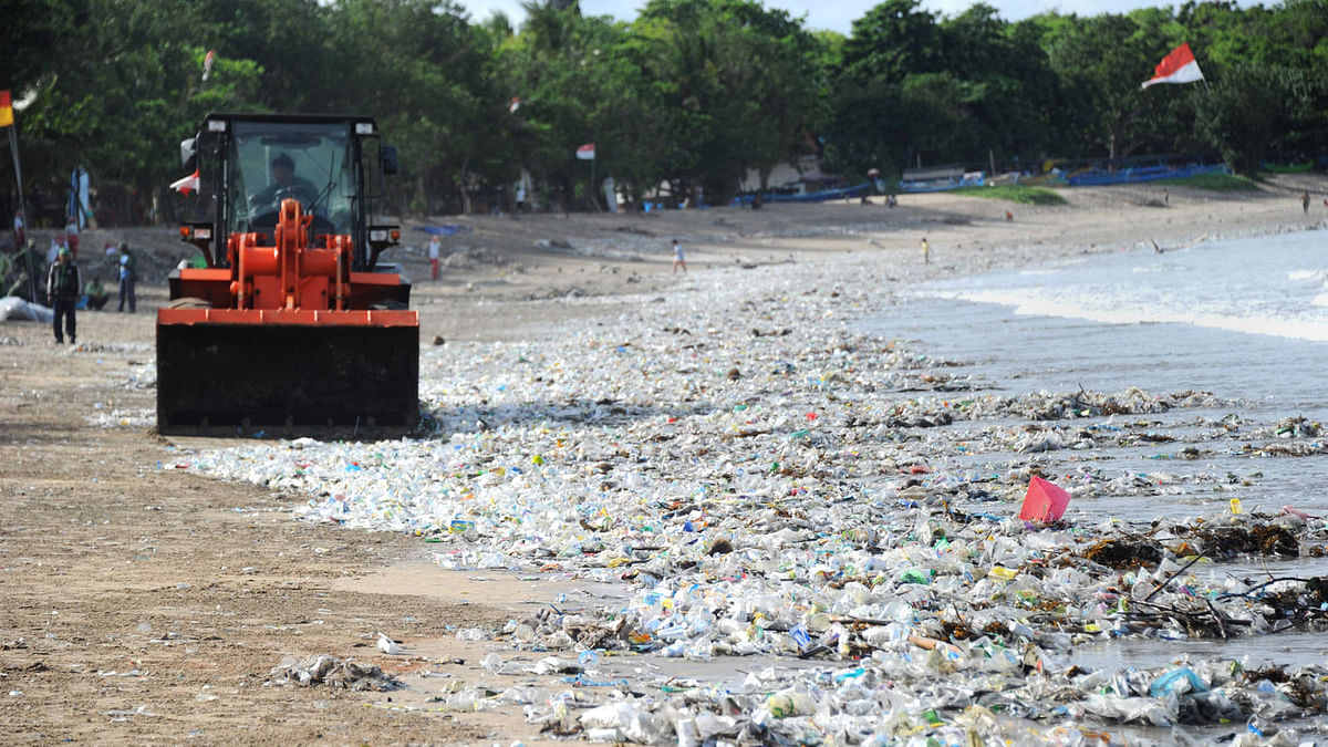 In this file photo taken on 19 December 2017 shows rubbish collectors using heavy equipment to clear plastic trash on Kuta beach near Denpasar, on Indonesia's tourist island of Bali. AFP