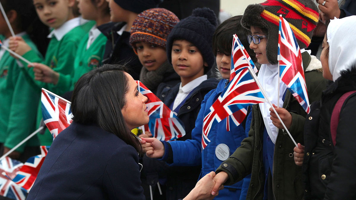 Meghan Markle talks to local school children during a walkabout with Britain`s Prince Harry during a visit to Birmingham, Britain on 8 March. Photo: Reuters
