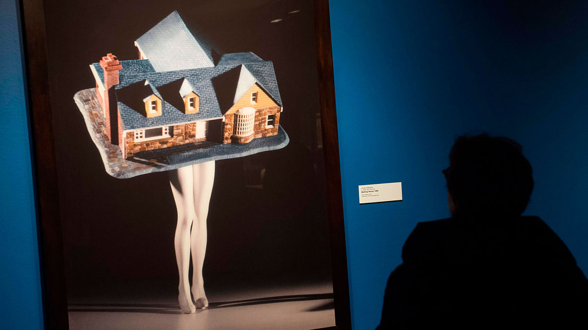 A museum guest looks at `Walking House,` by artist Laurie Simmons, as she tours the exhibition, `Women House,` featuring global artists and their reinterpretations about women in the home, during a preview showing at the National Museum of Women in the Arts in Washington, DC on 8 March. Photo: AFP