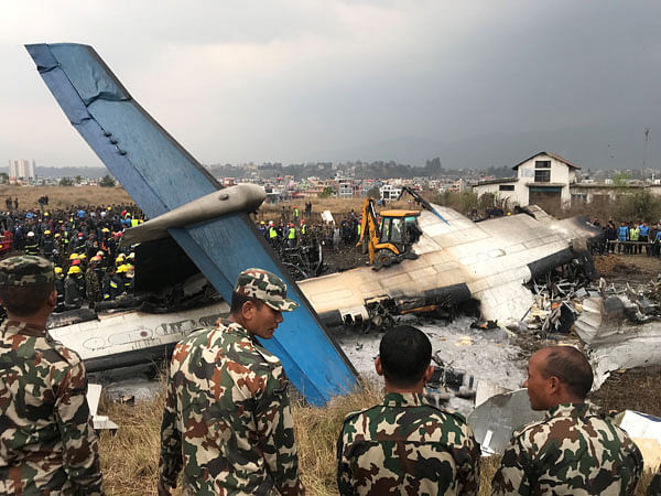 Wreckage of an airplane is seen as rescue workers operate at Kathmandu airport