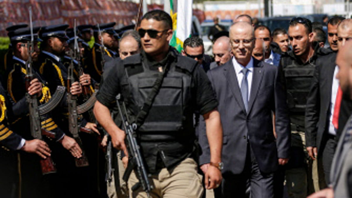 Palestinian Prime Minister Rami Hamdallah (2nd-R), escorted by his bodyguards, is greeted by police forces of the Islamist Hamas movement (L) upon his arrival in Gaza City on March 13, 2018 Photo : AFP