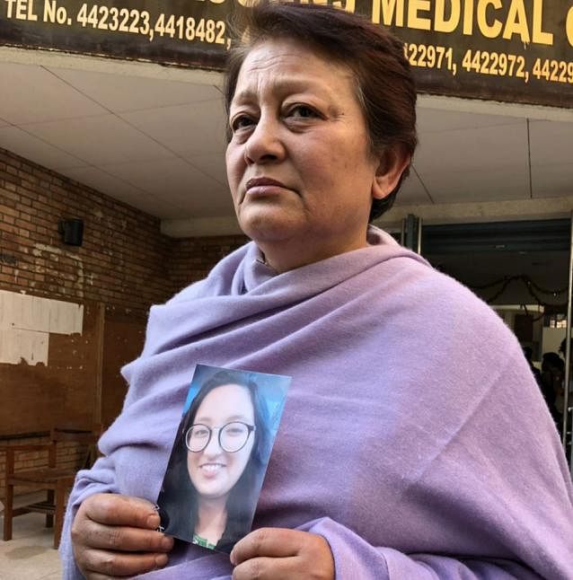 Cap 3: Sylhet Rageeb-Rabeya Medical College student Shreta Thapa's mother Urmila Prodhan waits holding photo of her daughter in front of the morgue of the Kathmandu Medical College Teaching Hospital on 14 March. Photo: Kamrul Hasan
