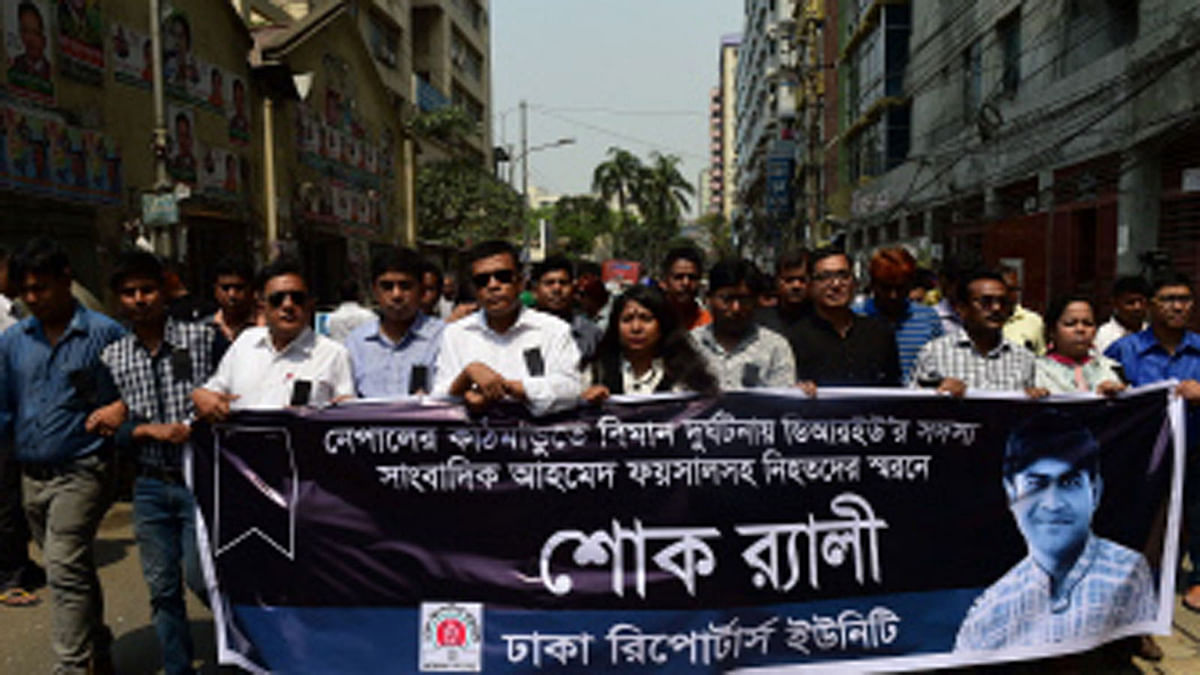 Dhaka Reporters` Unity (DRU) organises a rally as they observe a national day of mourning in Dhaka on 15 March 2018 in memory of the victims of the US-Bangla Airlines plane crash in Kathmandu, including their colleague Ahmed Faisal, a staff reporter for private television channel Boishakhi TV, whose image they are holding on a banner. Photo: AFP